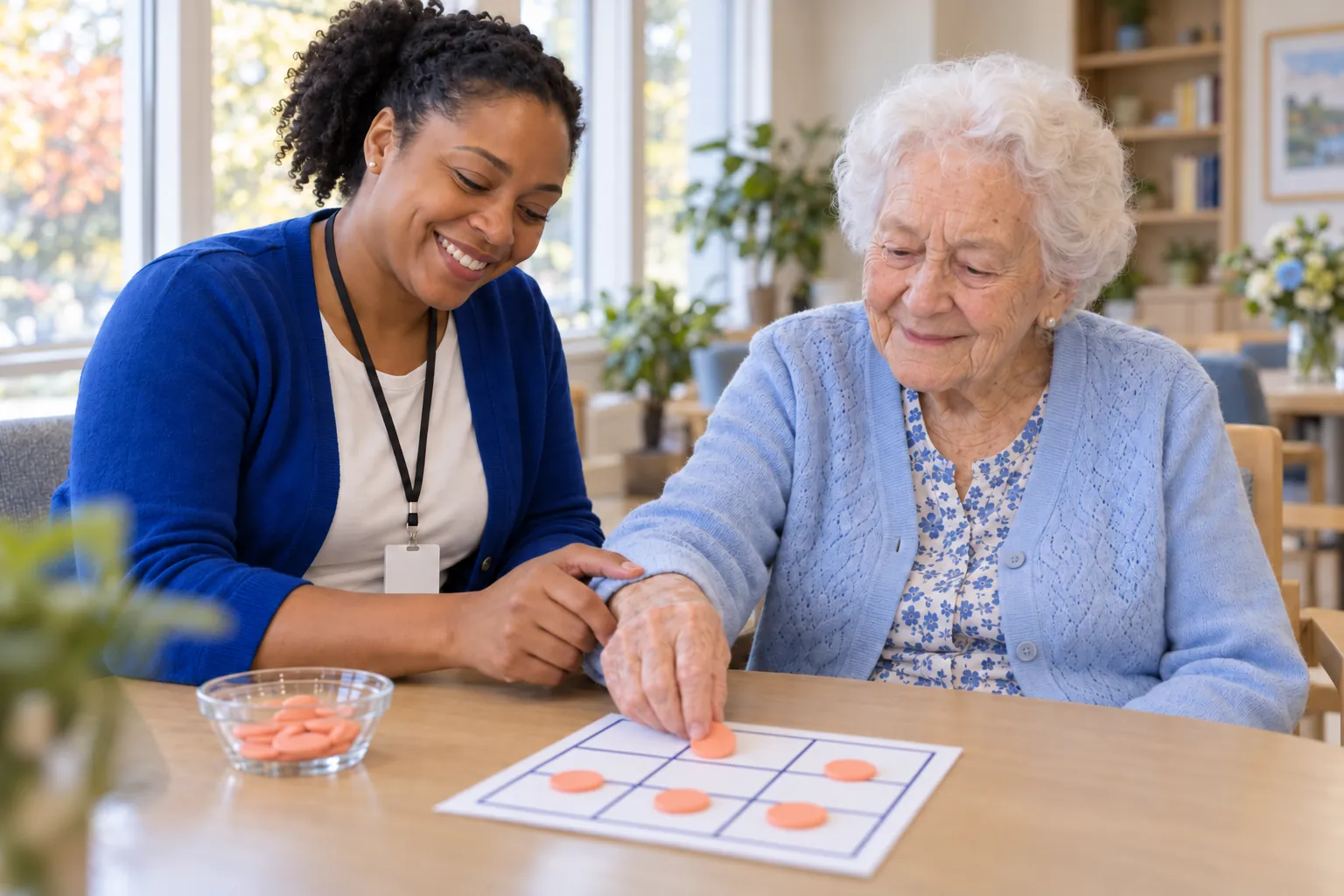 An activity assistant gently guides a resident’s hand as she places a chip on a large-print three-by-three bingo card